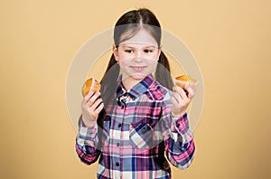 Making bakery style cupcakes. Cute little girl holding cupcakes in bakery shop. Small child with fresh sweet bakery food