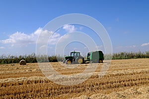 making bales tractor working in rice harvest season