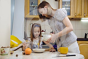 Making breakfest. Mom teach daughter to cook