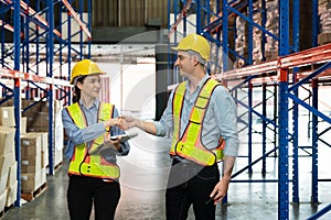 Making a business deal. A man and a woman, well dressed in an elegant suit with a protective yellow helmet