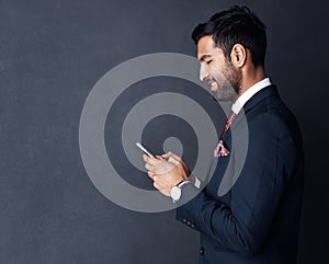 Making daily business dealings more efficient with smart technology. Studio shot of a young businessman using a mobile