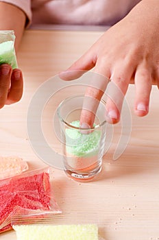 Making candles by yourself . Little girl making candle in the glass from soy wax parsley flakes