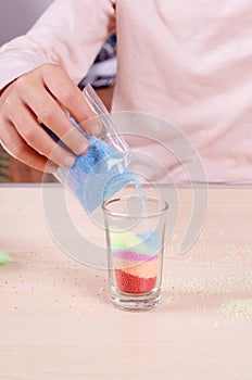 Making candles by yourself . Little girl making candle in the glass from soy wax parsley flakes