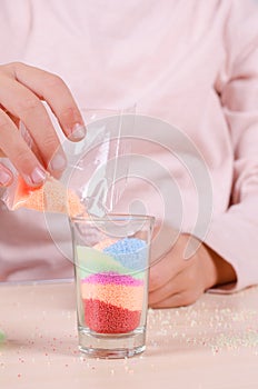 Making candles by yourself . Little girl making candle in the glass from soy wax parsley flakes