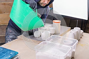 Making and casting decorative dishes and vases from plaster for home decoration in the workshop. Pouring plaster into special