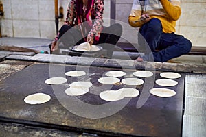 Making of chapati round flatbreads for langar in sikh gurudwara temple many uncooked roti flatbreads