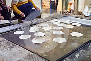 Making of chapati round flatbreads for langar in sikh gurudwara temple many uncooked roti flatbreads