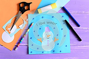 Making a children winter paper cards. Step. Paper card with snowman collage and text I love winter. Stationery and materials