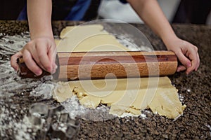 Making Christmas cookies with sugar cookie dough and a rolling pin