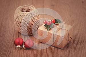 Making christmas gits, a box with holly berries, baubles and twine ribbon, handmade