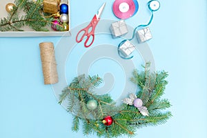 Making a Christmas wreath. Spruce branch, ornaments, scissors. B