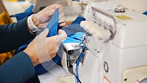 Making clothes. Woman works with cloth on Sewing Machine. Focus on cloth