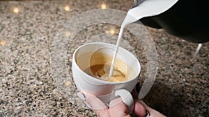 Making coffee. Barista prepares coffee. Preparation of latte. Barista pouring hot milk into a mug of espresso. latte art