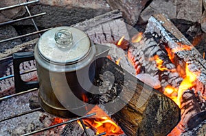 Making coffee over a campfire in the woods of a forest.
