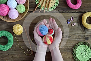 Making colored crochet balls. Toy for babies and toddlers to learn mechanical skills and colors. On the table threads, needles,