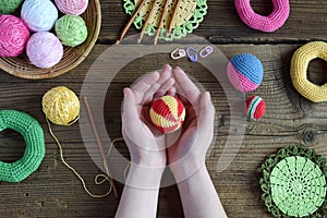 Making colored crochet balls. Toy for babies and toddlers to learn mechanical skills and colors. On the table threads, needles,