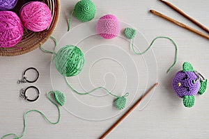 Making colored crochet bird. Toy for babies or trinket.  On the table threads, needles, hook, cotton yarn. Handmade gift. DIY