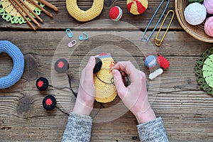 Making colored crochet racing car. Toy for babies and toddlers to learn mechanical skills and colors. On the table threads,