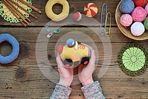 Making colored crochet racing car. Toy for babies and toddlers to learn mechanical skills and colors. On the table threads,