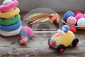 Making colored crochet racing car. Toy for babies and toddlers to learn mechanical skills and colors. On the table threads,