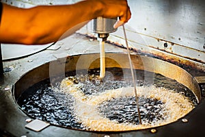 Making cooking of spanish churros churreria