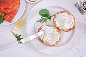 Making cream cheese and salmon toatst - woman smearing cream cheese on a grilled bun