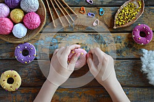 Making crochet amigurumi donuts. Toy for babies or trinket.  On the table threads, needles, hook, cotton yarn. Handmade gift. DIY