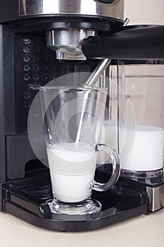 Making cup of latte in carob coffee maker