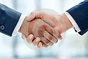 Making deals happen. Closeup shot of two businesspeople shaking hands together in an office.