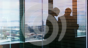 Making decisions as a team. Silhouette shot of two businesspeople having a discussion inside an office building.