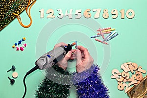 Making decorations for birthday celebrations-decorative candles for a cake with an electric engraver. The numbers symbolize the