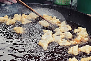 Making deep-fried dough stick in market.