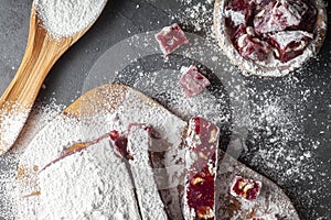 Making of delicious fruit flavored homemade Turkish delight with vibrant pink red color and mixed with hazelnuts.