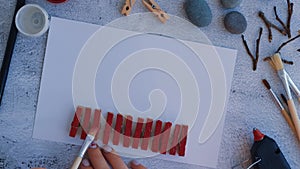 Making Diy Merry Christmas deer on greeting card postcard made of pebbles, sea stones, clothespins and branches on white