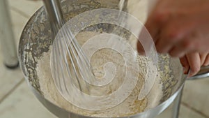 Making dough in bowl, pouring out flour, whipping all ingredients with whisk