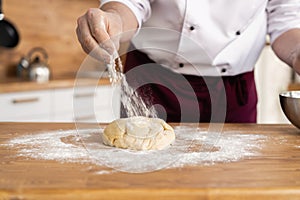 Making dough by male hands at bakery