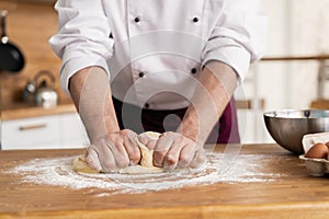 Making dough by male hands at bakery
