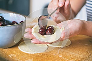 Making dumplings filled with sour cherry with sugar