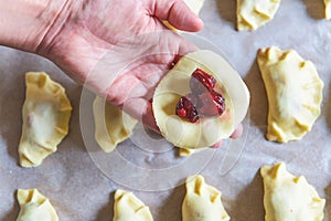 Making dumplings filled with sour cherry with sugar