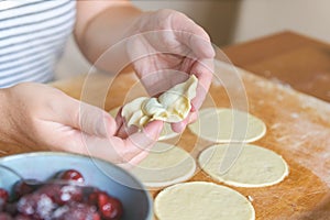 Making dumplings filled with sour cherry with sugar