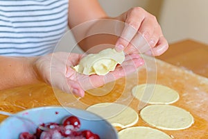 Making dumplings filled with sour cherry with sugar