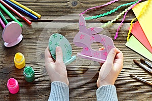 Making Easter decoration - easter eggs and bunny. Painting and coloring wooden toy of brushes and gouache. Creative process.