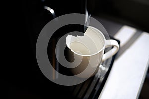 Empty white cup in coffee machine