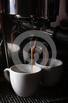 Making fresh aromatic espressos using professional coffee machine in cafe, closeup photo