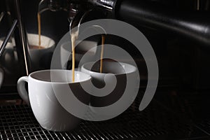 Making fresh aromatic espressos using professional coffee machine in cafe, closeup. Space for text