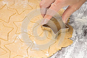 Making ginger bread christmas cookies with metal cutter. Ginger dough and flour photo