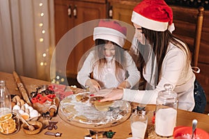 Making gingerbread at home. Little girl cutting cookies of gingerbread dough. Christmas and New Year traditions concept