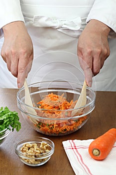 Making grated carrot salad, tossing a salad