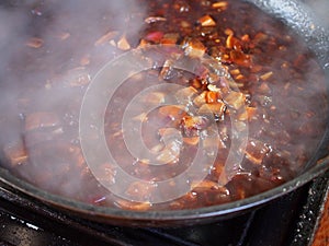 Making gravy using red onions garlic tomato and mushroom