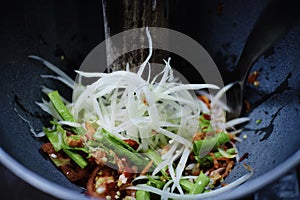 Making of green papaya salad with ingredients crab dried shrimp are mixing and pounding in a mortar. we call ` Som tum ` in Thai